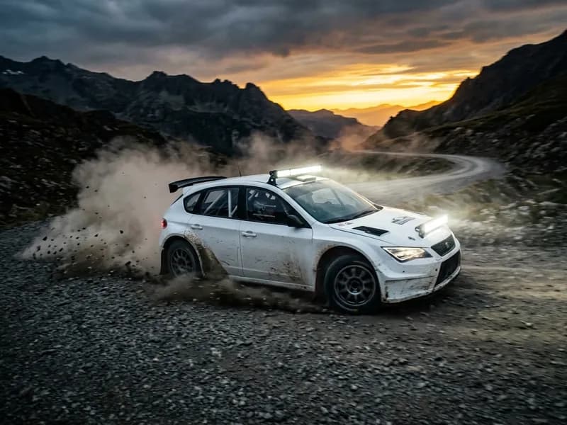 Voiture rallye blanche en dérapage sur piste de montagne avec barre LED Homologuée FFSA Next-Tech frontale allumée au crépuscule