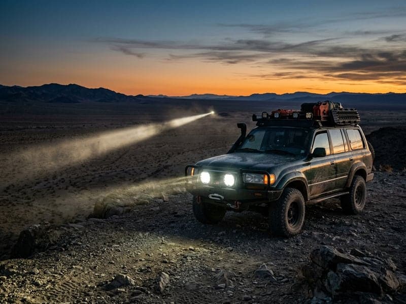 4x4 Toyota Land Cruiser équipé de phares LED longue portée Next-Tech allumés au crépuscule dans le désert